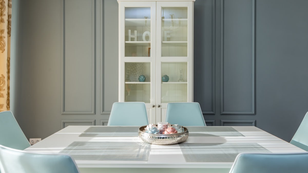 Elegant dining room with pastel chairs and a chic cabinet, perfect for modern homes.